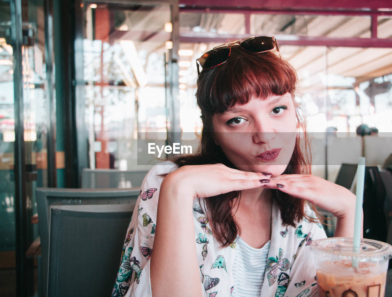 Portrait of beautiful young woman puckering at restaurant