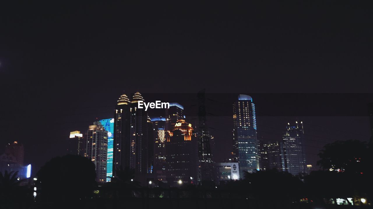 ILLUMINATED BUILDINGS AGAINST SKY AT NIGHT