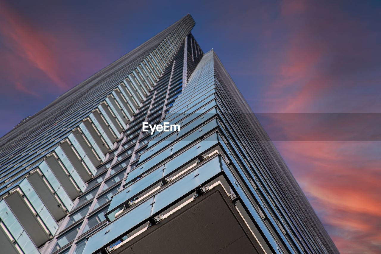 LOW ANGLE VIEW OF BUILDING AGAINST SKY AT DUSK