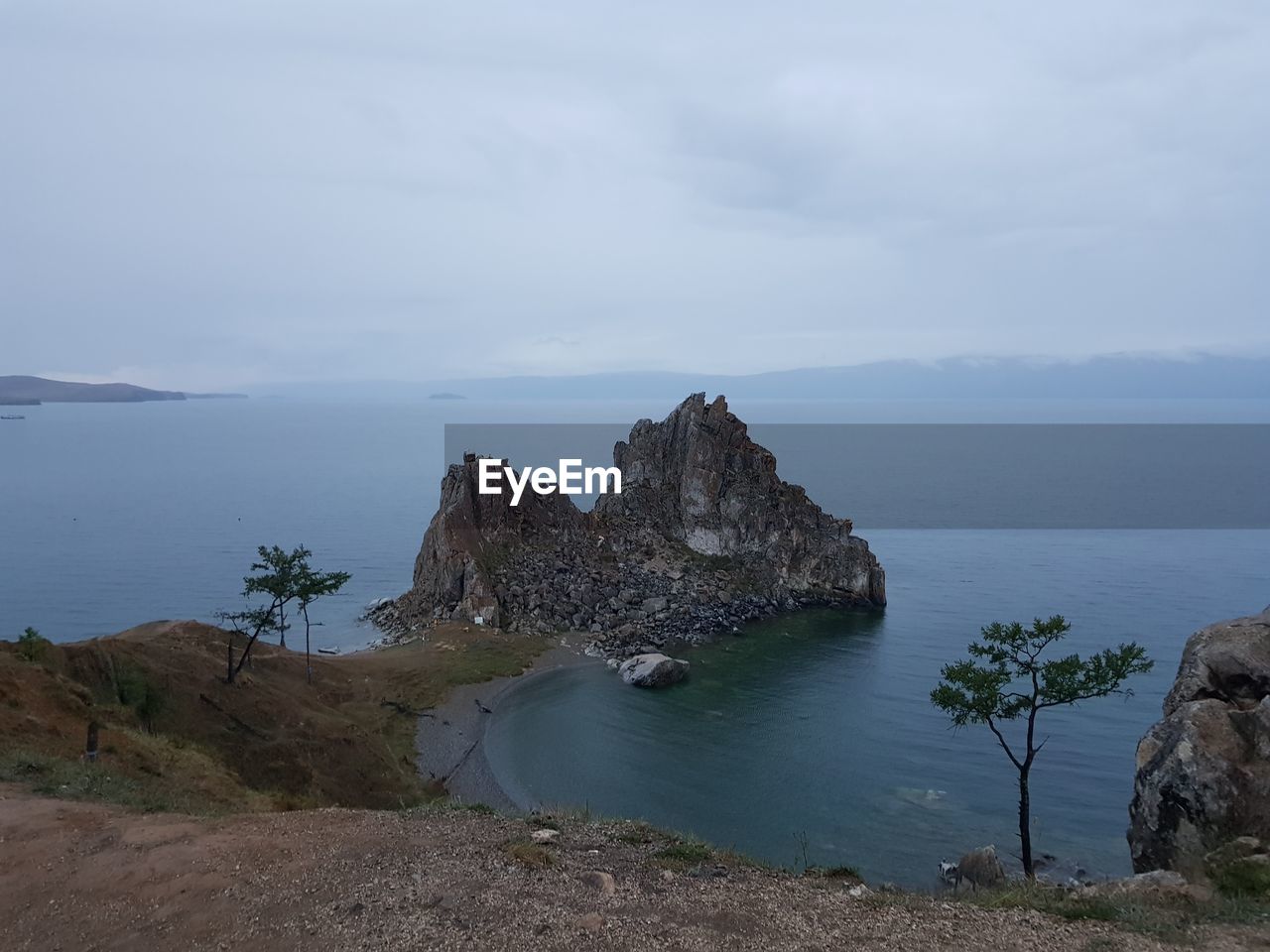 Scenic view of rocks on sea shore against sky