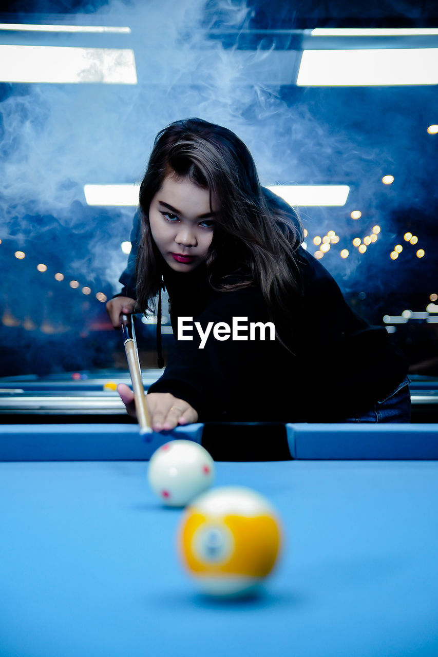 portrait of woman playing pool