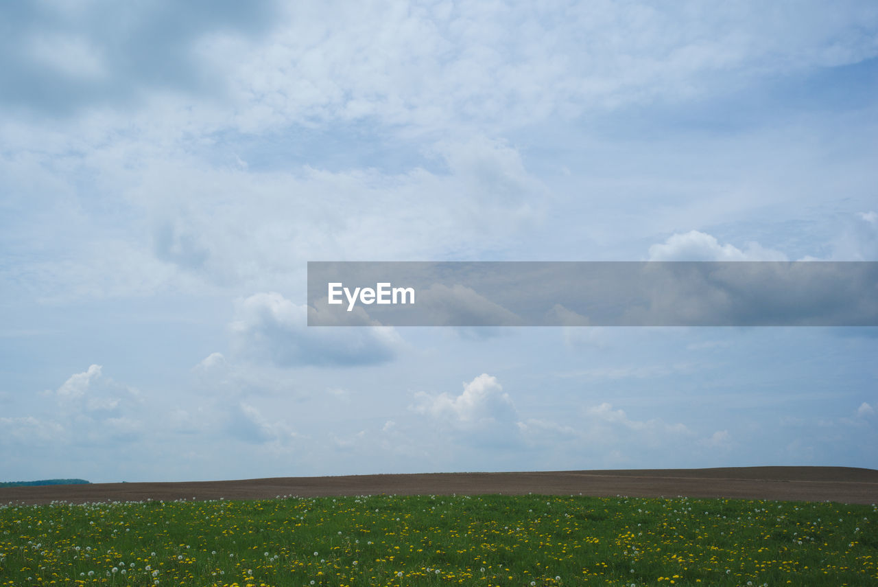 VIEW OF FIELD AGAINST CLOUDY SKY