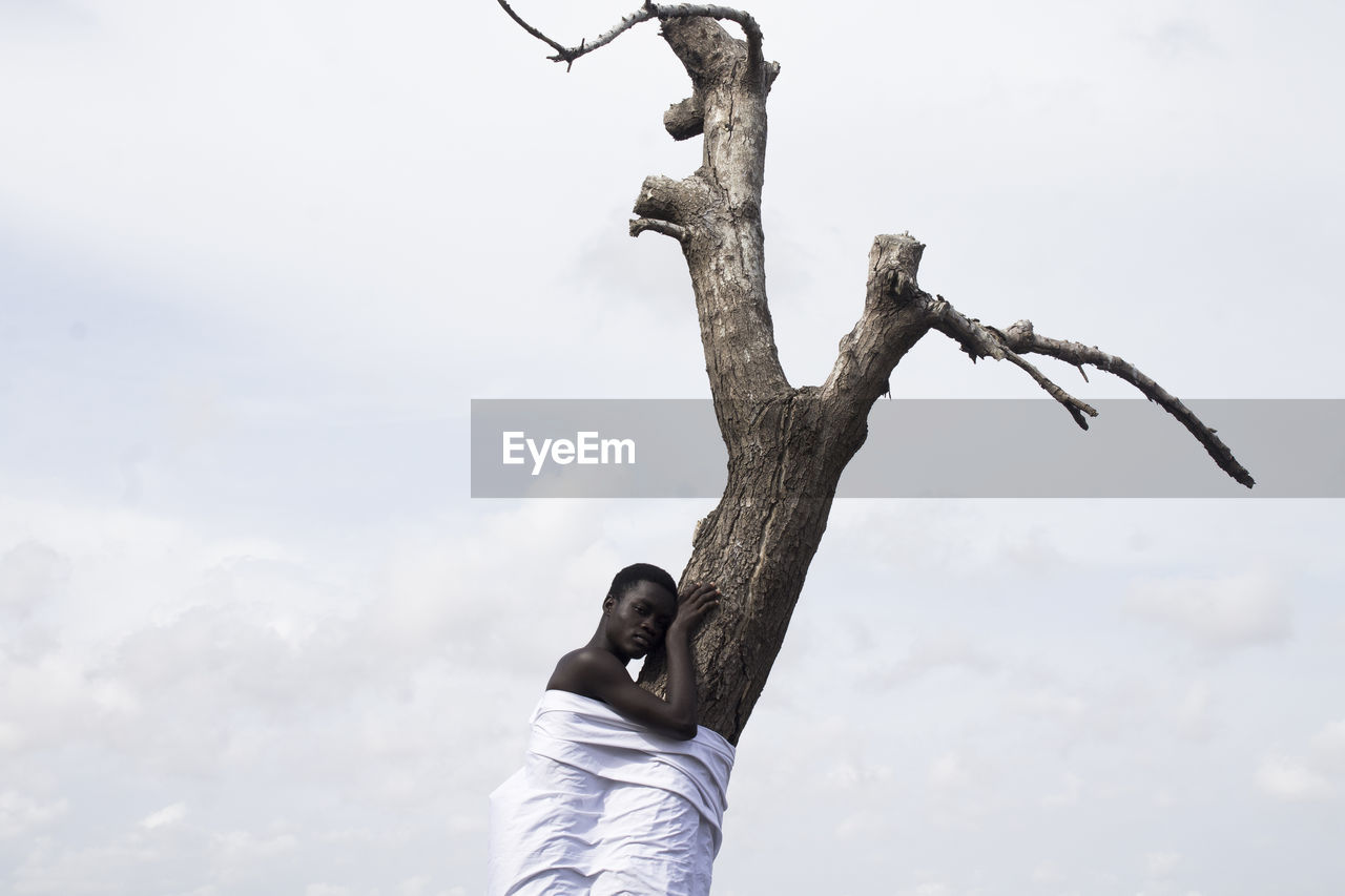 LOW ANGLE VIEW OF MAN AGAINST SKY