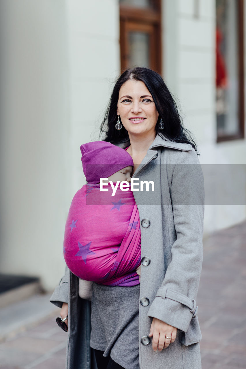 Woman carrying son in scarf 