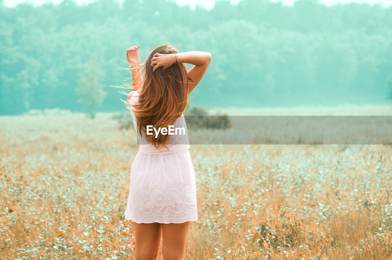 Rear view of woman standing on field