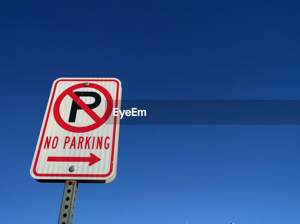 Low angle view of no parking sign against clear sky