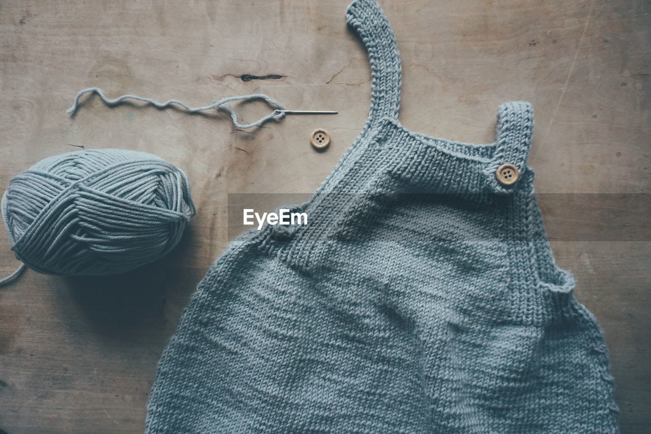 High angle view of knitting baby clothing