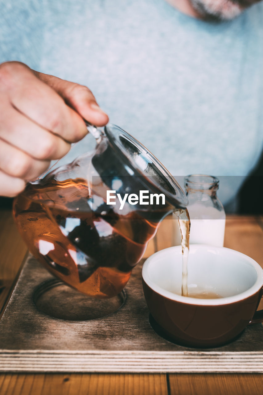 Close-up of hand pouring tea