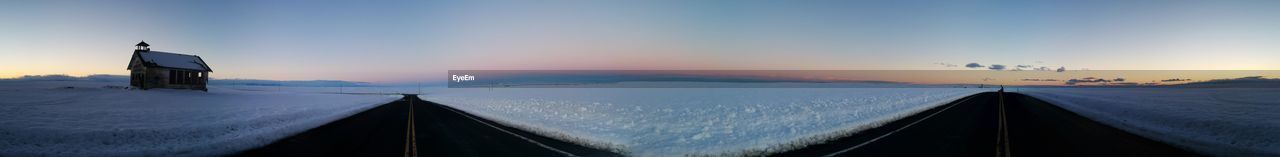 PANORAMIC VIEW OF SNOWY FIELD AGAINST SKY DURING SUNSET