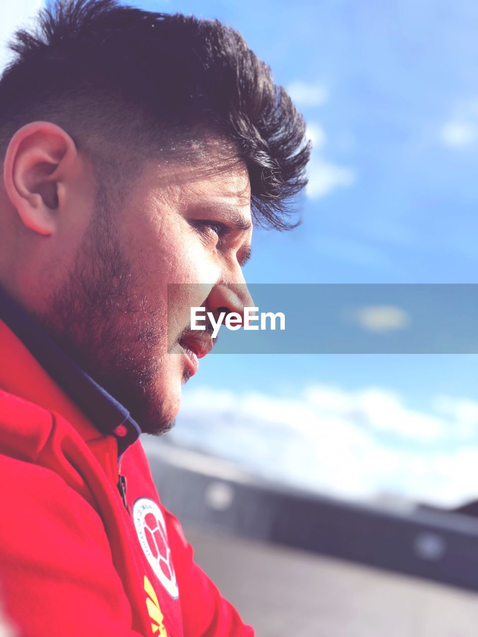 CLOSE-UP PORTRAIT OF YOUNG MAN LOOKING AWAY OUTDOORS