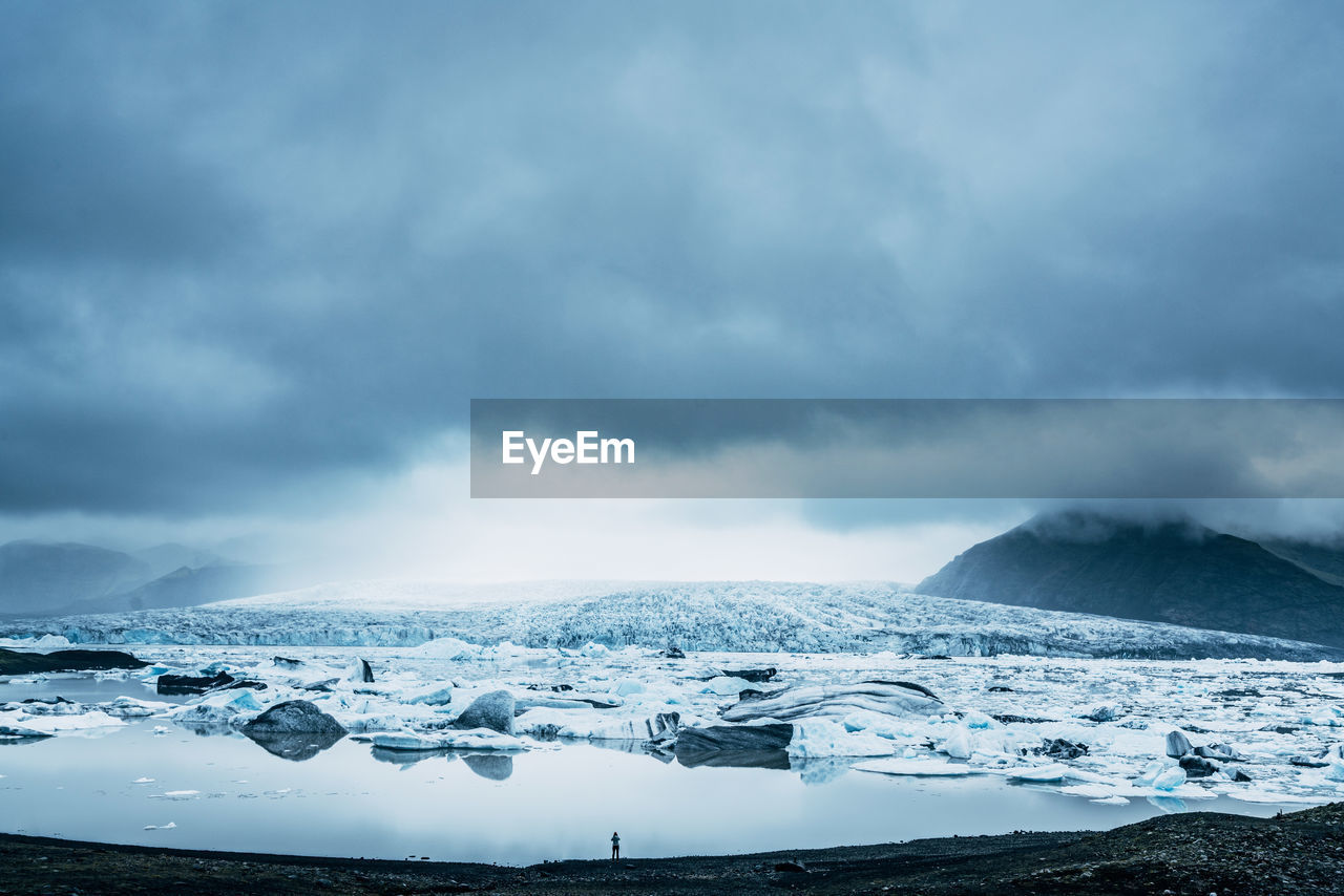 Close-up of snow on shore against sky