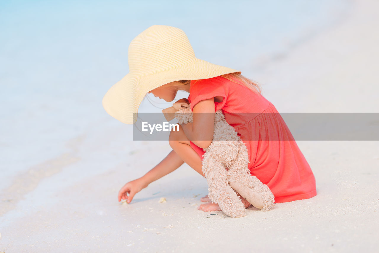 Full length of woman wearing hat on beach