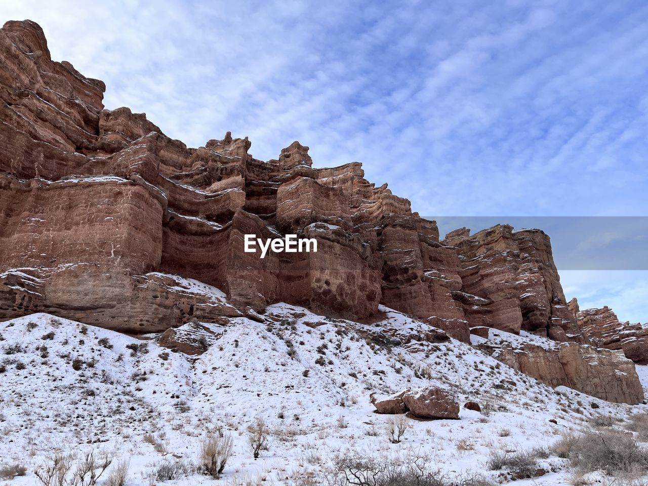 rock, rock formation, scenics - nature, sky, landscape, nature, environment, beauty in nature, travel destinations, mountain, valley, travel, non-urban scene, land, no people, cloud, tranquility, geology, snow, tranquil scene, plateau, outdoors, wilderness, desert, day, eroded, extreme terrain, winter, formation, cold temperature, wadi, tourism, arch, blue, physical geography, remote, terrain, natural environment, mountain range