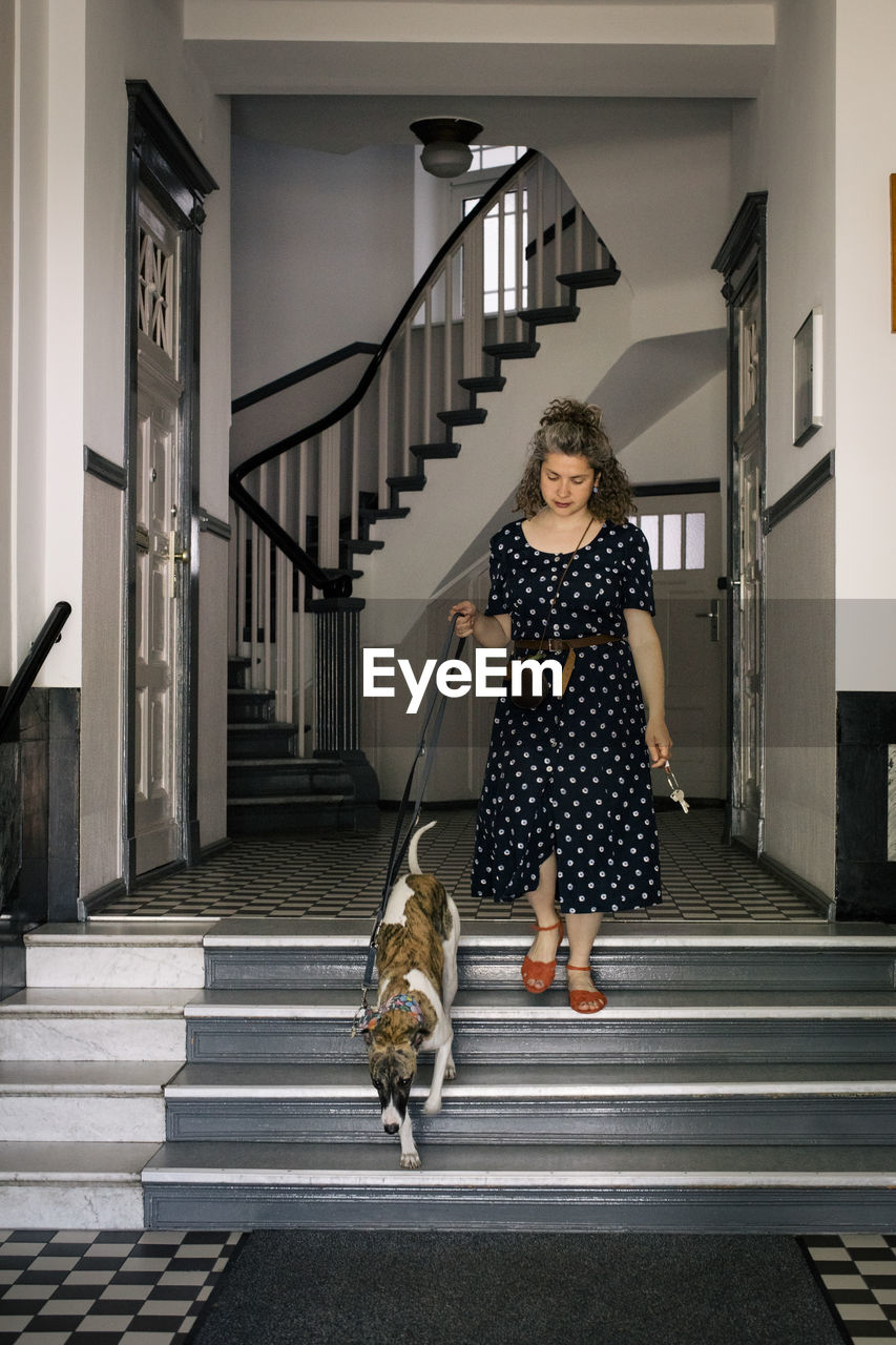 Woman moving down on steps with dog