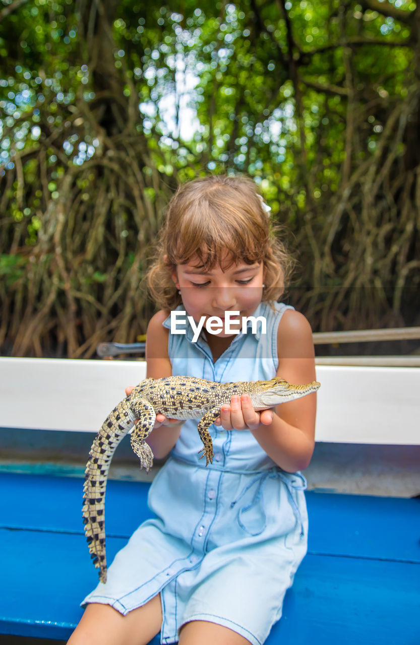 Girl holding alligator