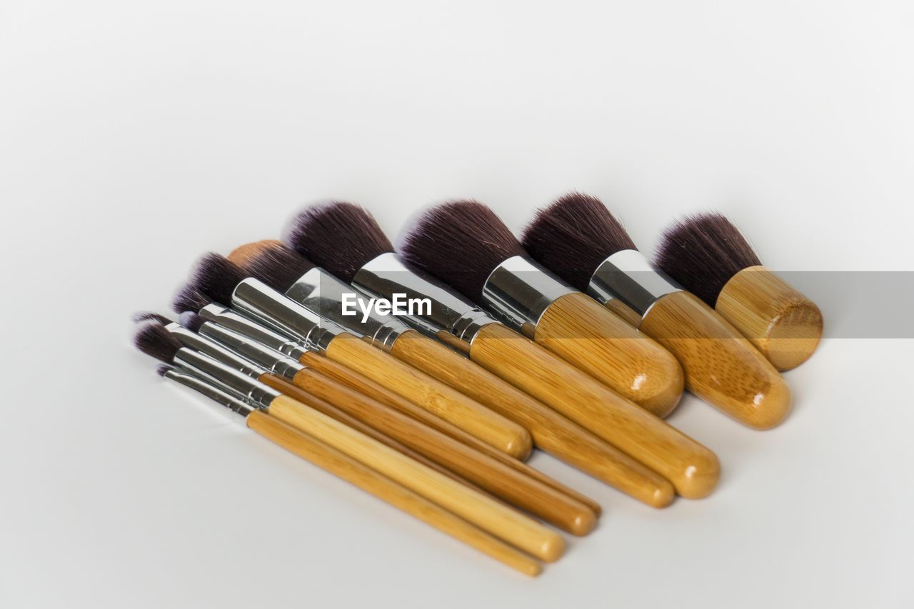 Close-up of make-up brushes over white background