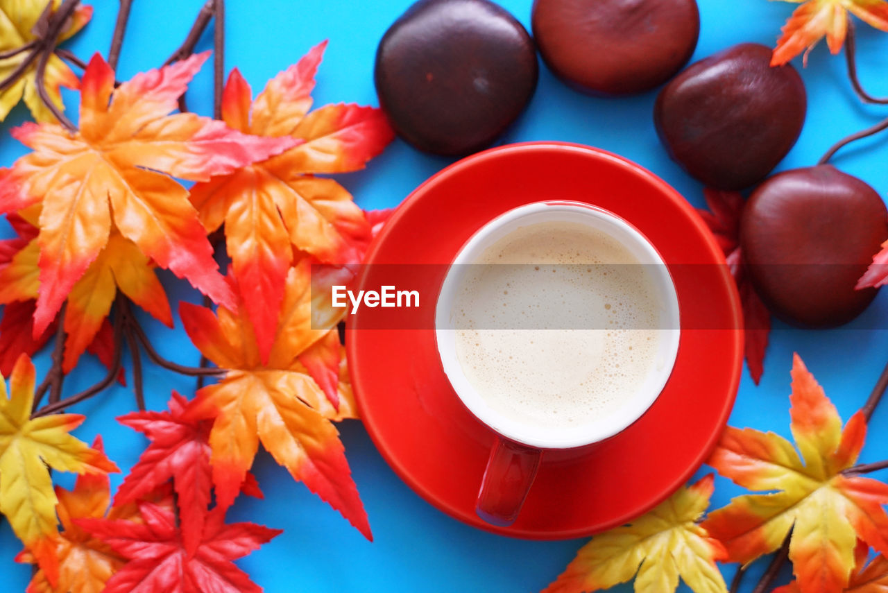 High angle view of coffee on table with autumn leaf