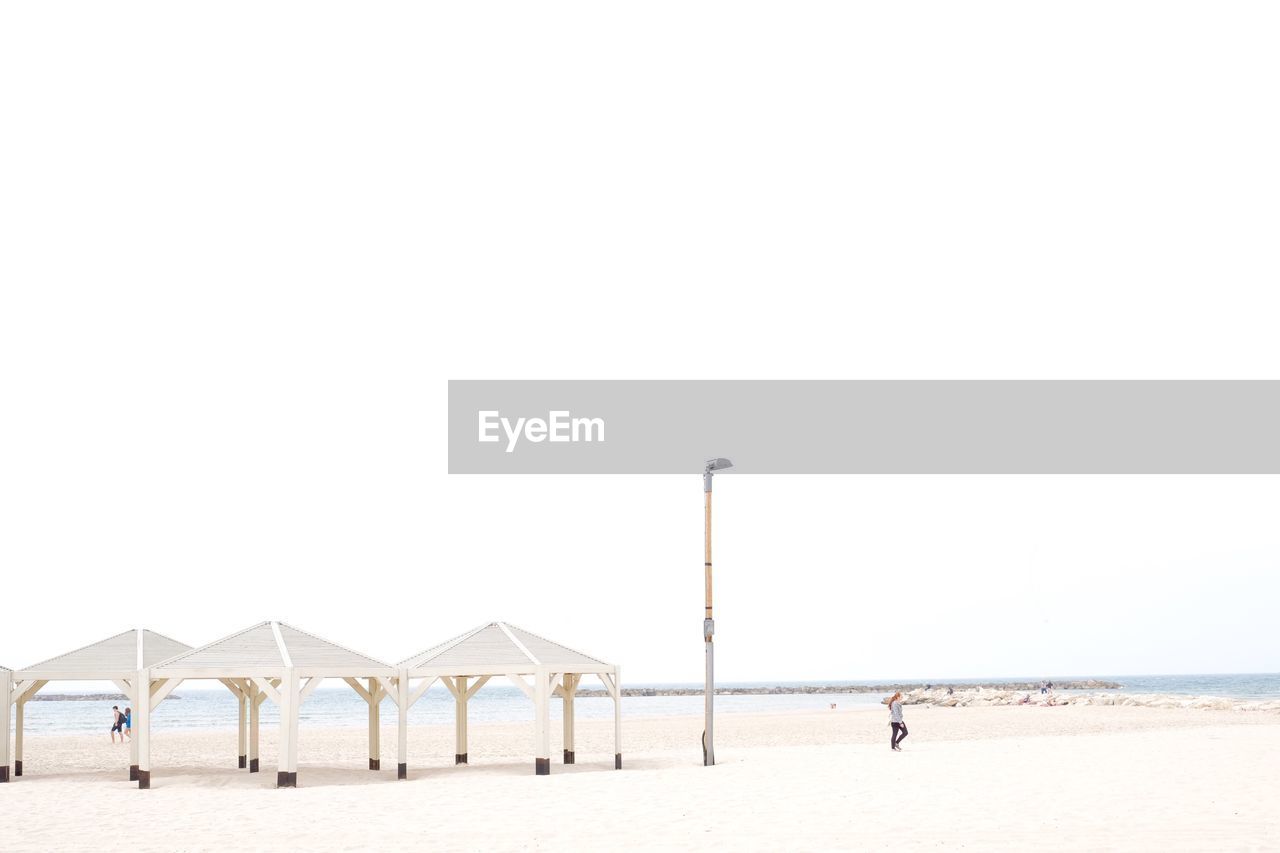 Woman at sandy beach against sky