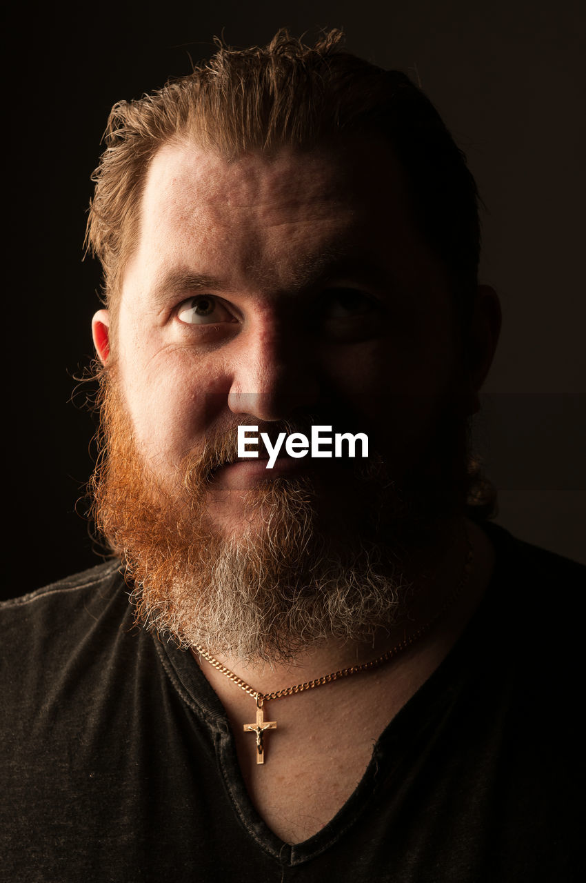 CLOSE-UP PORTRAIT OF MAN WITH FACE AGAINST BLACK BACKGROUND