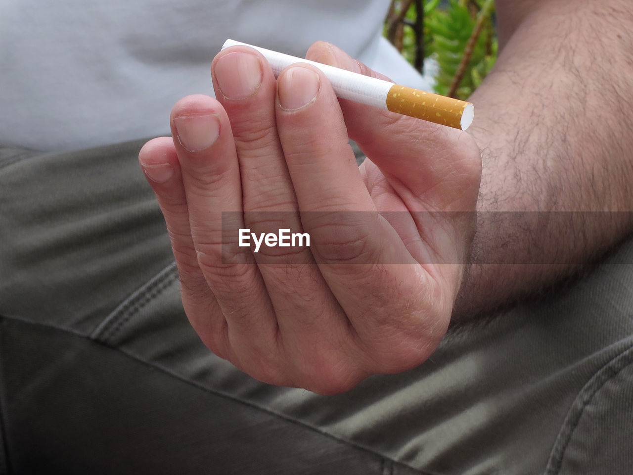 HIGH ANGLE VIEW OF MAN HOLDING CIGARETTE