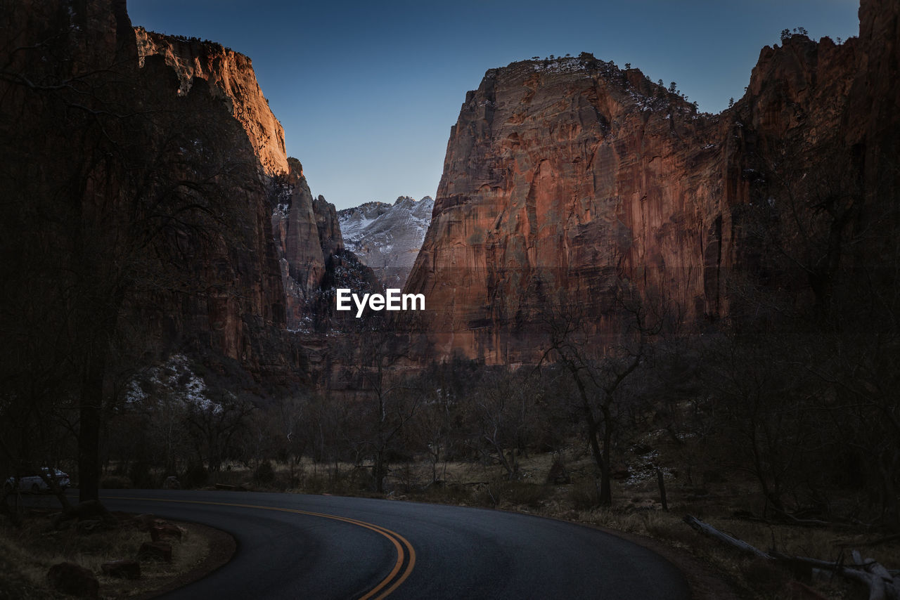 Road amidst rocky mountains against sky