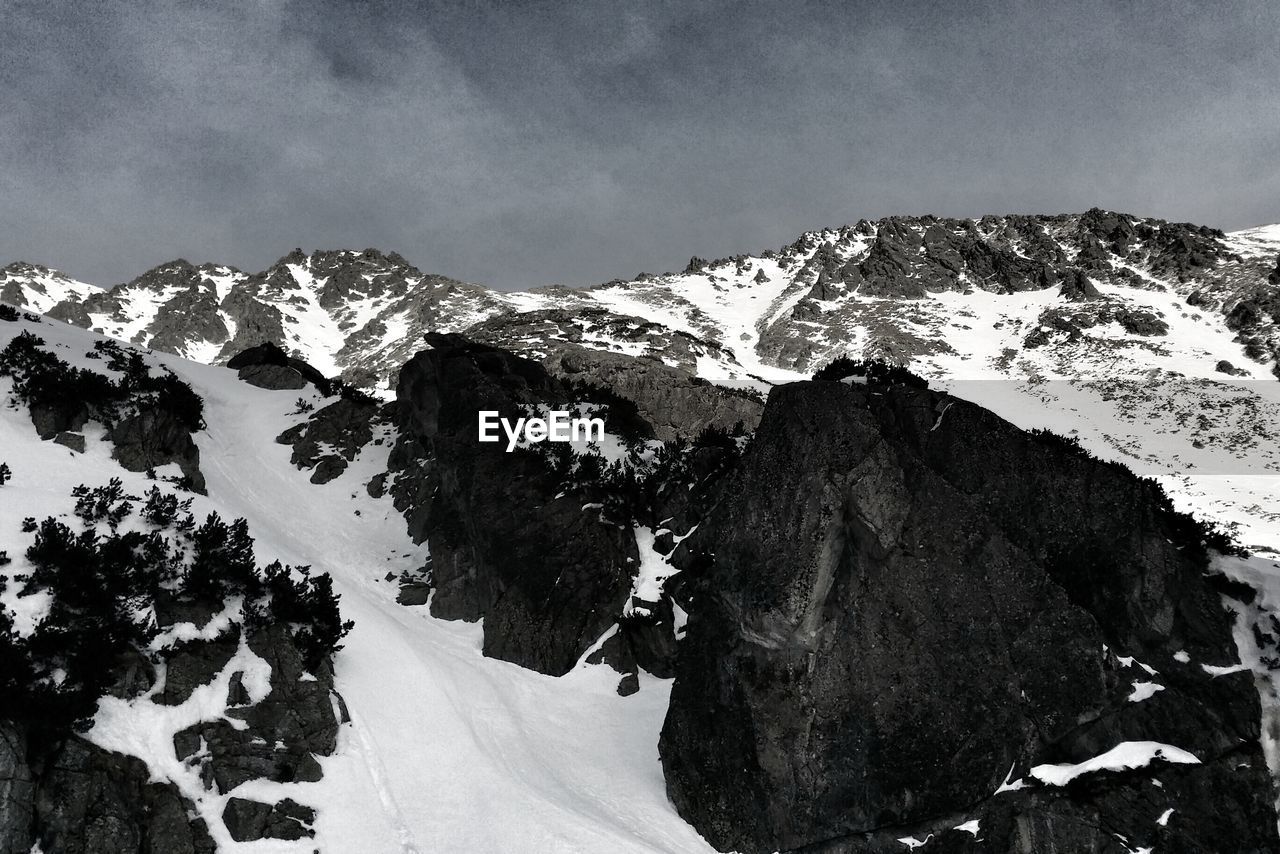 Scenic view of snow covered mountains against sky
