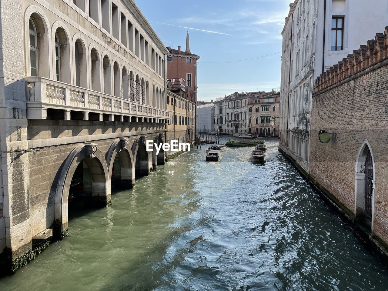 BRIDGE OVER CANAL BY BUILDINGS AGAINST SKY