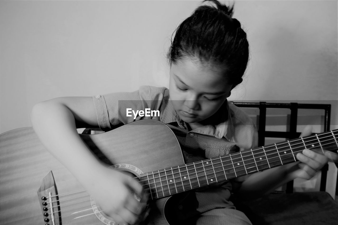 Boy playing guitar at home