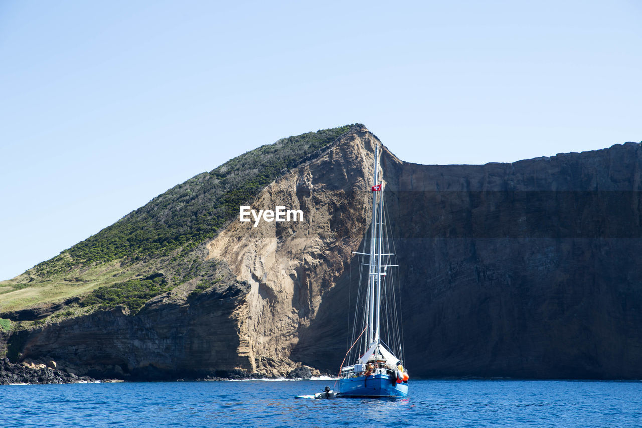 Sailboat sailing on sea against clear sky