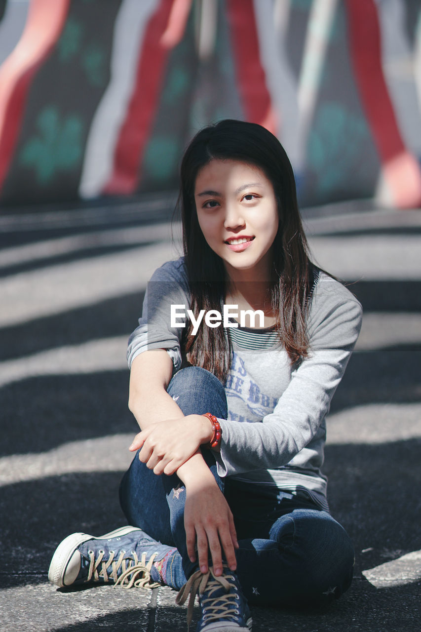 Portrait of a smiling girl sitting outdoors