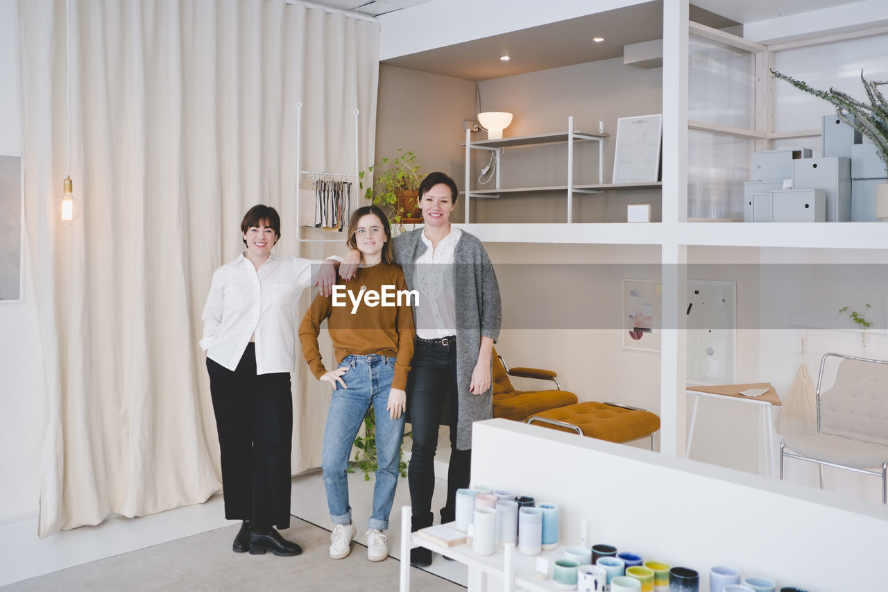 Full length portrait of female interior designers standing in store