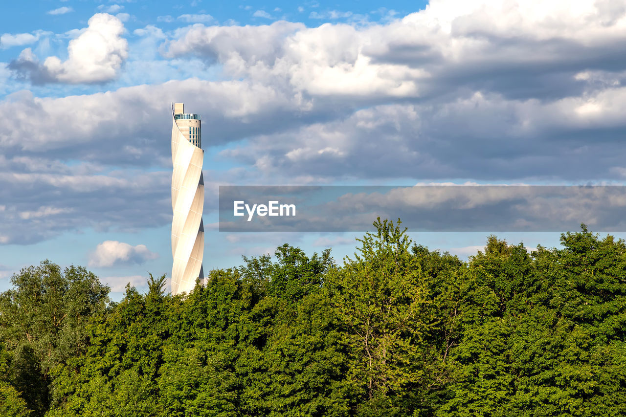 sky, cloud, tree, plant, tower, nature, no people, hill, day, architecture, environment, green, outdoors, travel, sunlight, wind, built structure, travel destinations, land, horizon, growth, low angle view, scenics - nature, lighthouse, blue