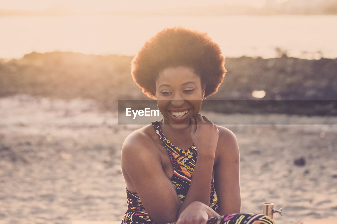 Smiling young woman sitting at beach