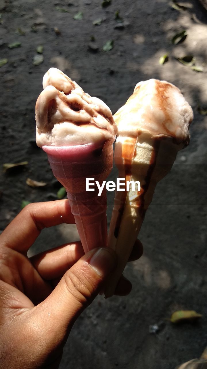 Cropped hand holding ice cream cones