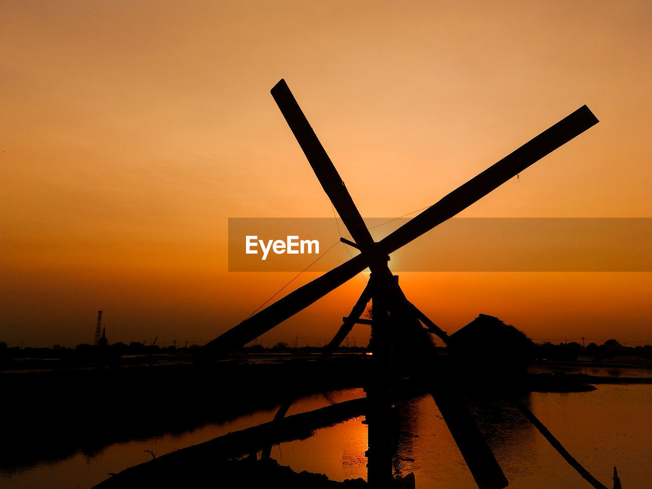 Silhouette windmill against sky during sunset