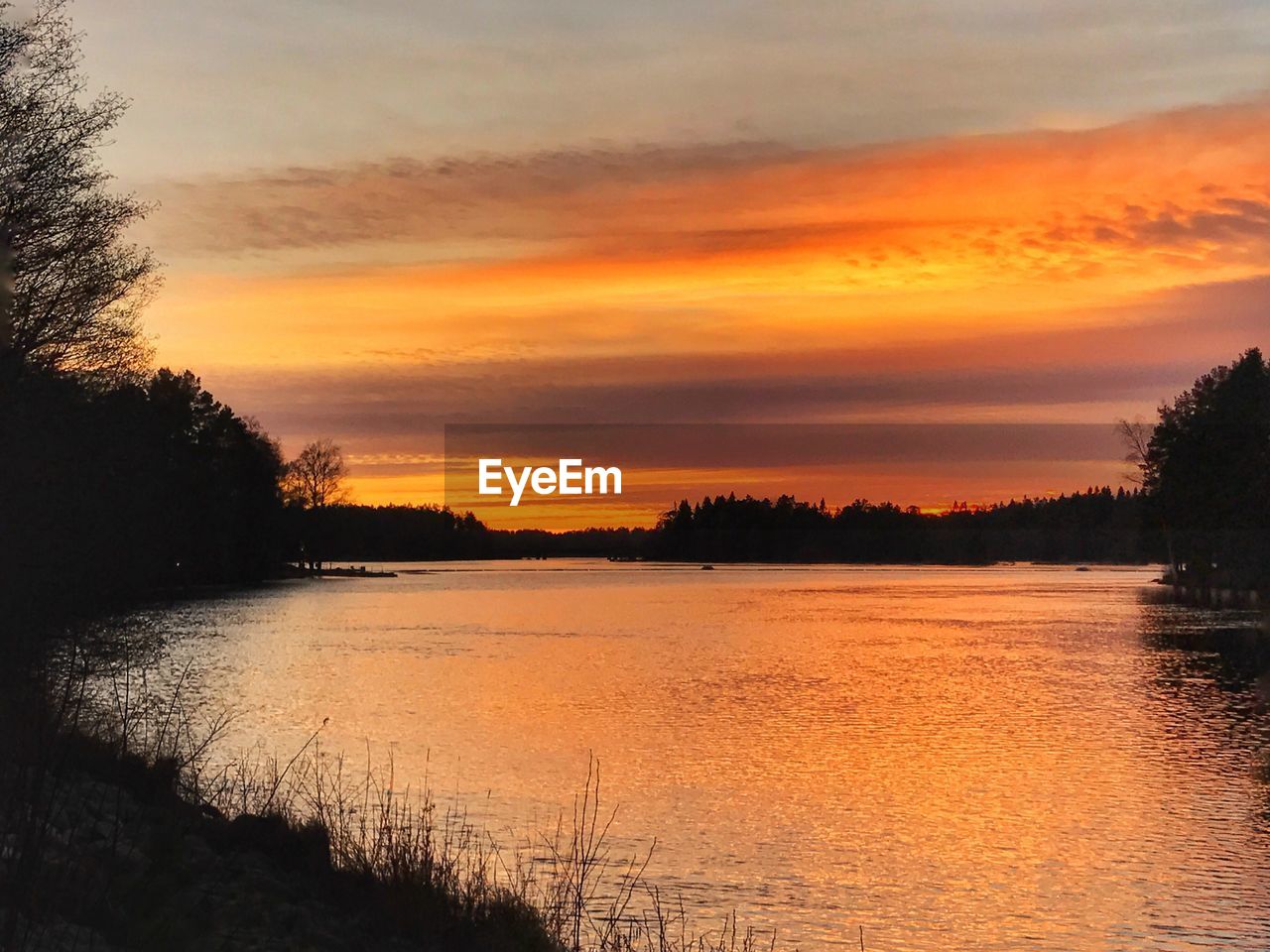 SCENIC VIEW OF LAKE AGAINST ORANGE SKY DURING SUNSET