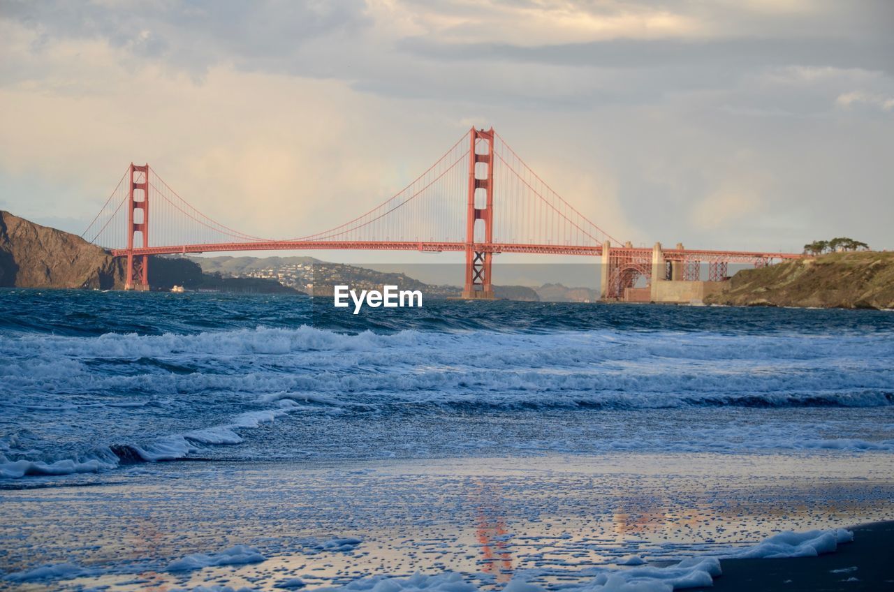 View of suspension bridge against cloudy sky