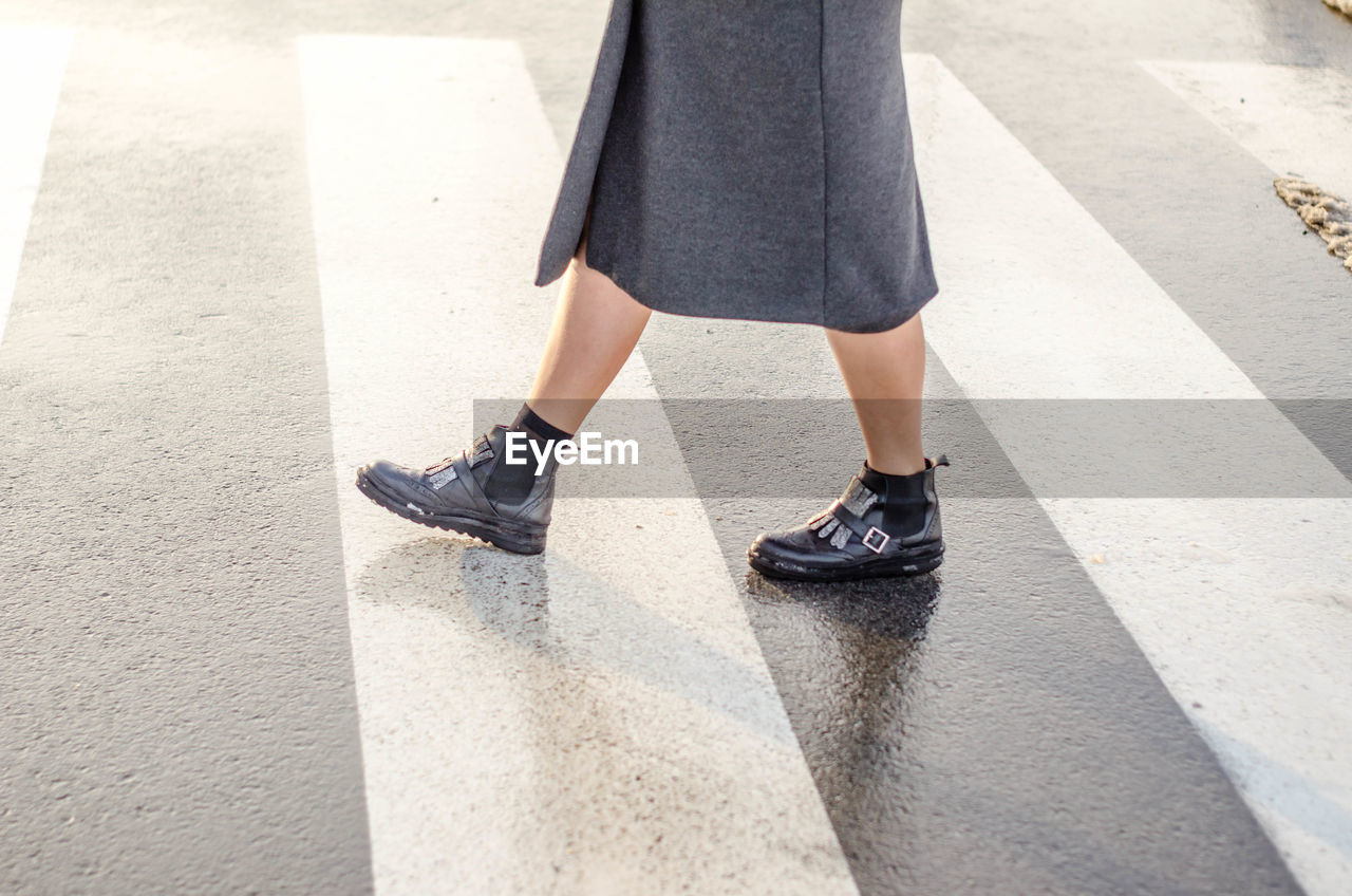 LOW SECTION OF WOMAN WALKING ON STREET