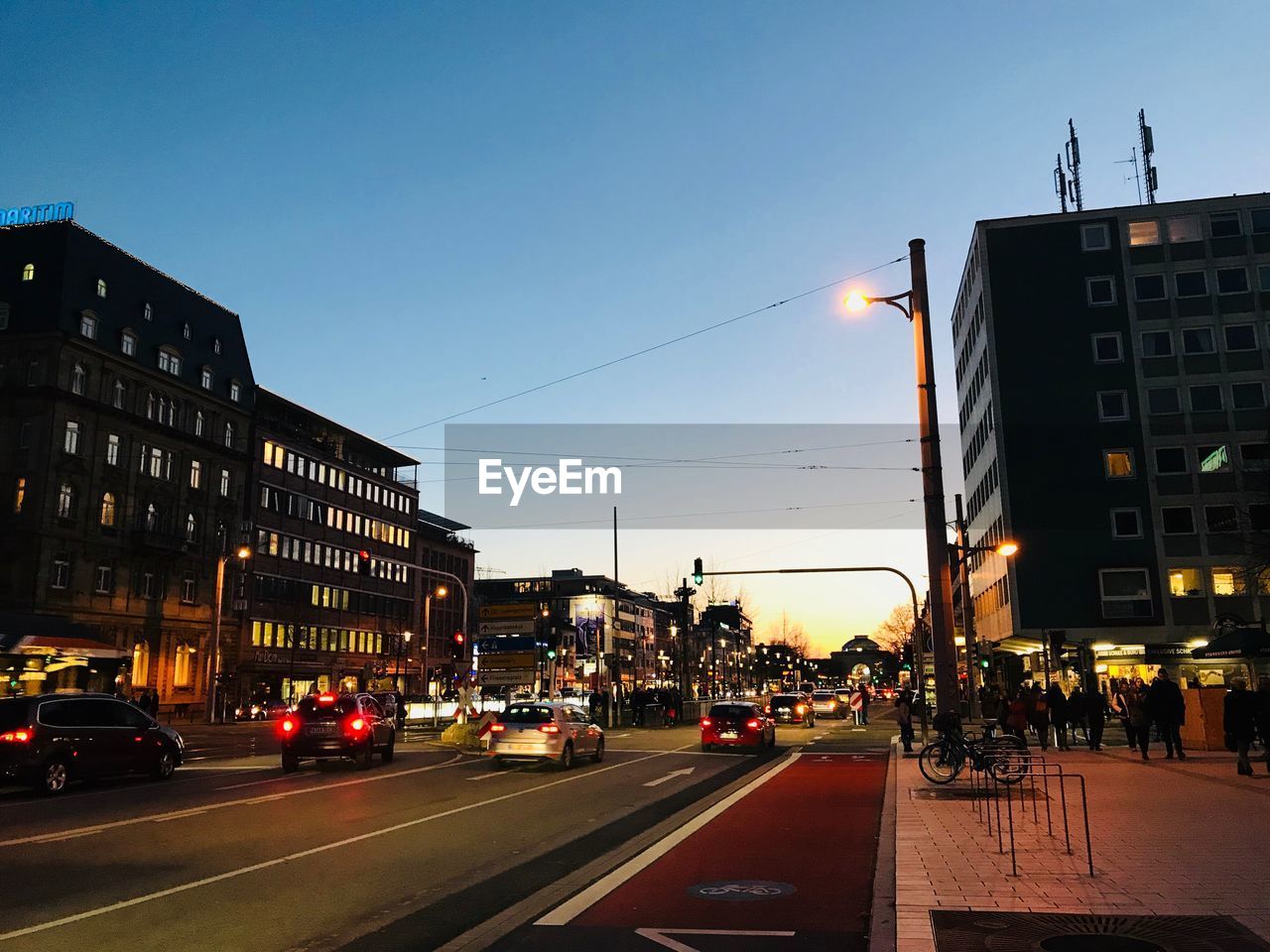 CARS ON CITY STREET AND BUILDINGS AGAINST SKY