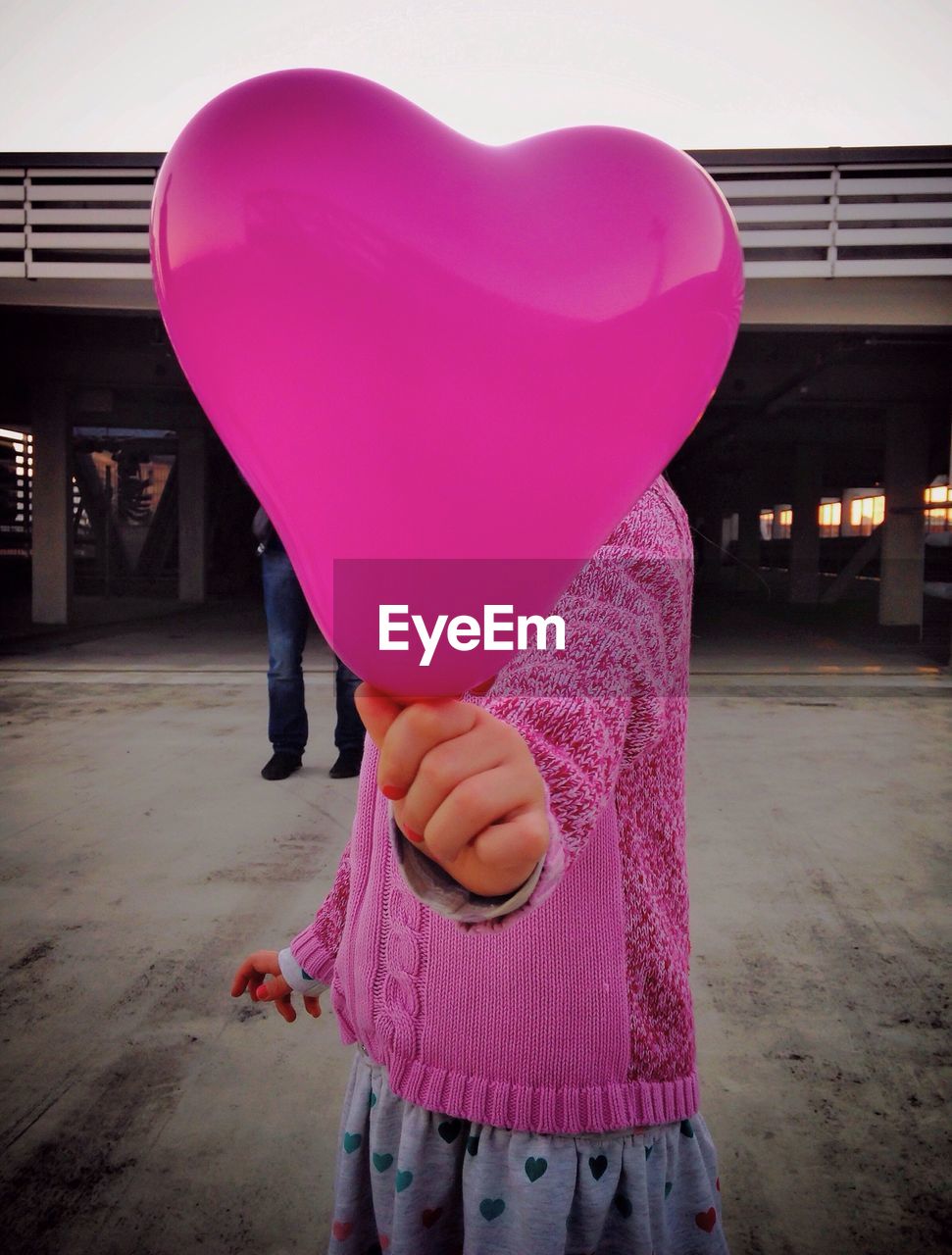 Little girl holding heart shaped balloon