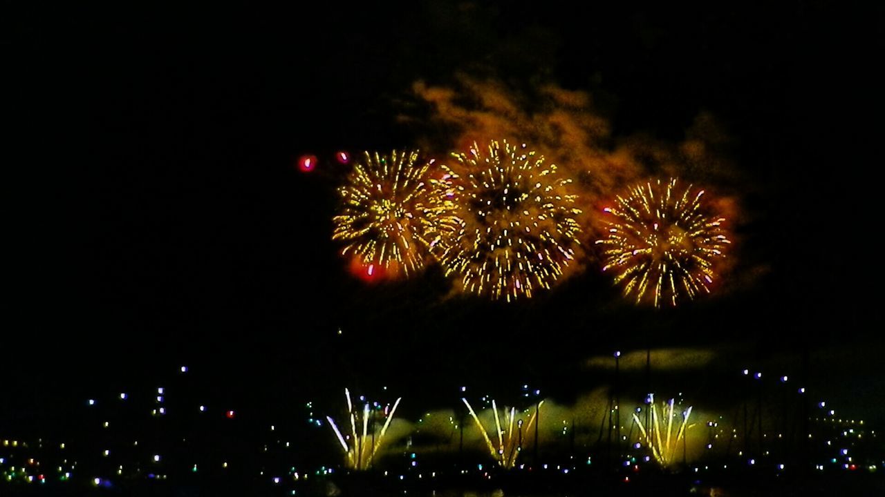 LOW ANGLE VIEW OF FIREWORK DISPLAY AT NIGHT