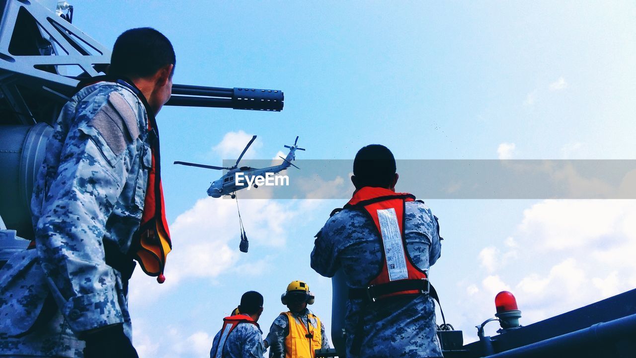 Rear view of army men against sky