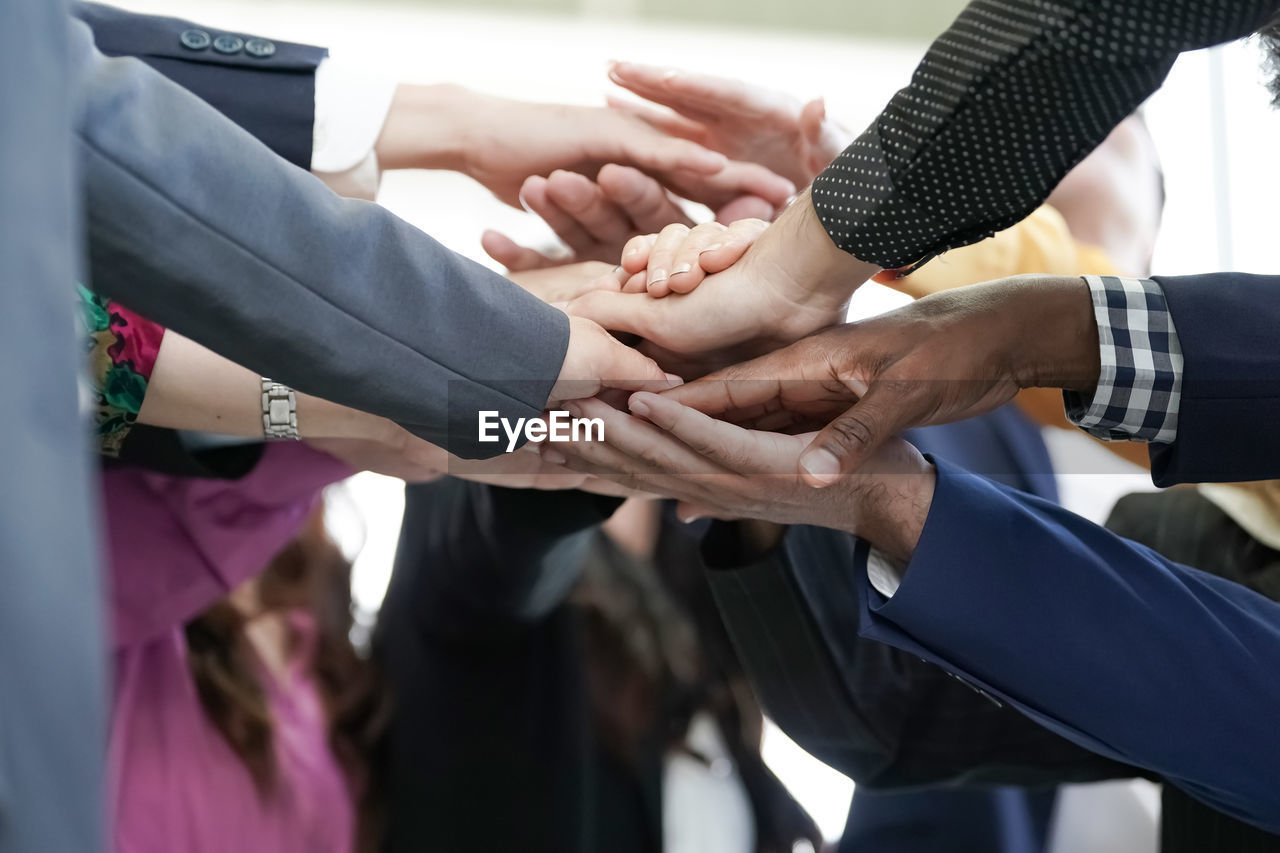 cropped image of business people stacking hands