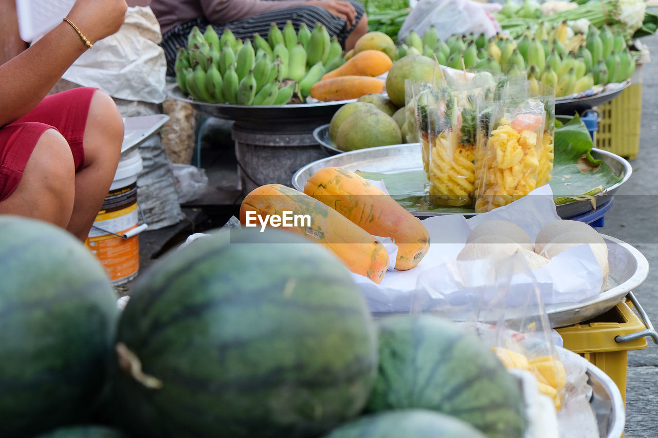 Midsection of person preparing fruits for sale in market