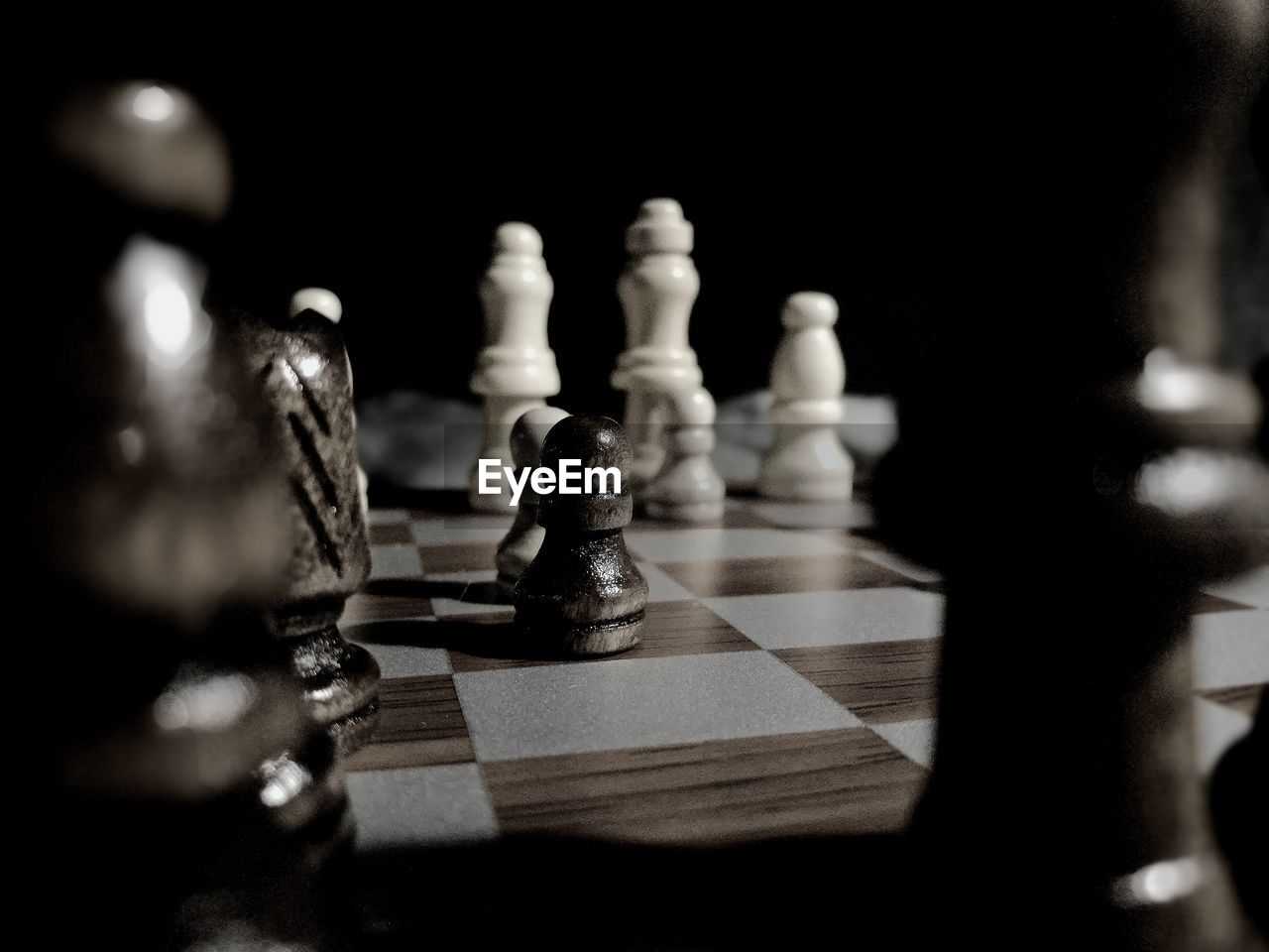 Close-up of chess pieces on board against black background