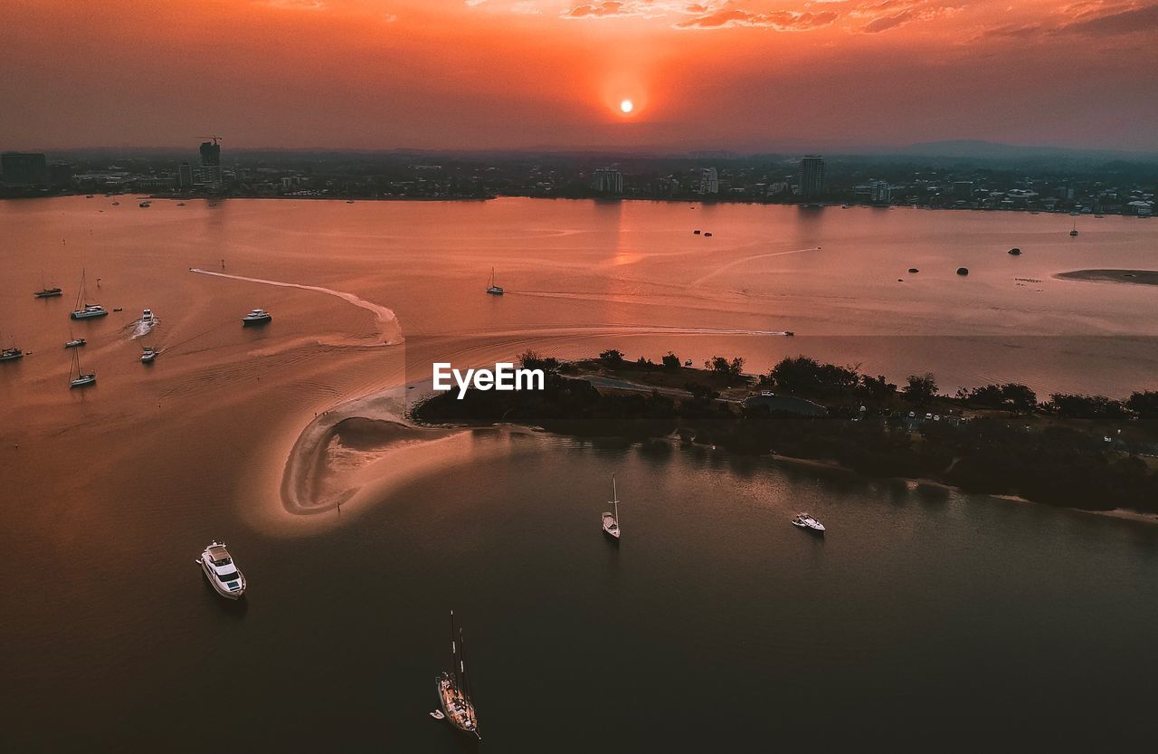 High angle view of city by sea against sky during sunset