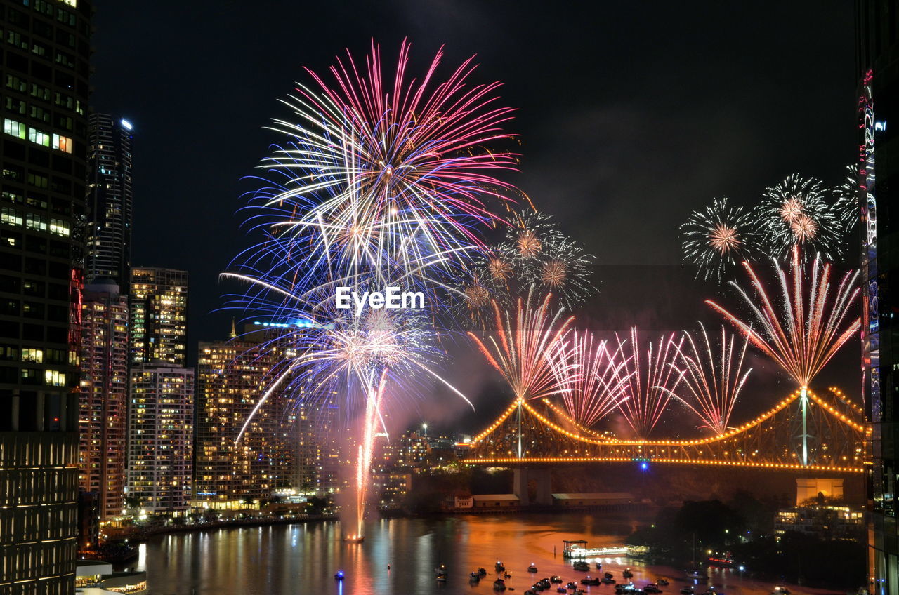 Firework display over river at night