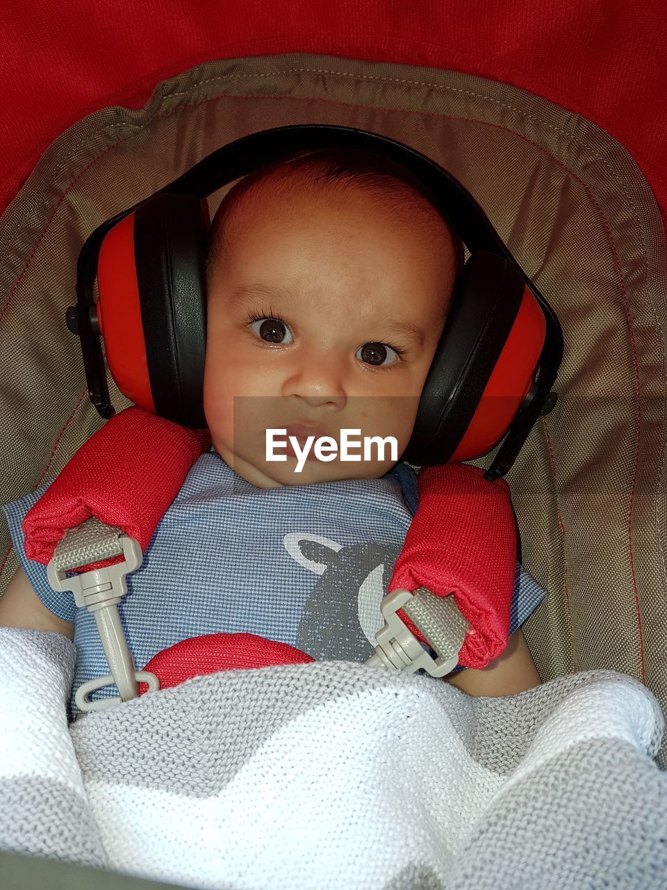 Portrait of baby wearing ear muffs while sitting in stroller
