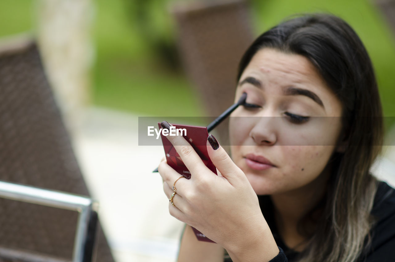 Portrait of woman applying make-up