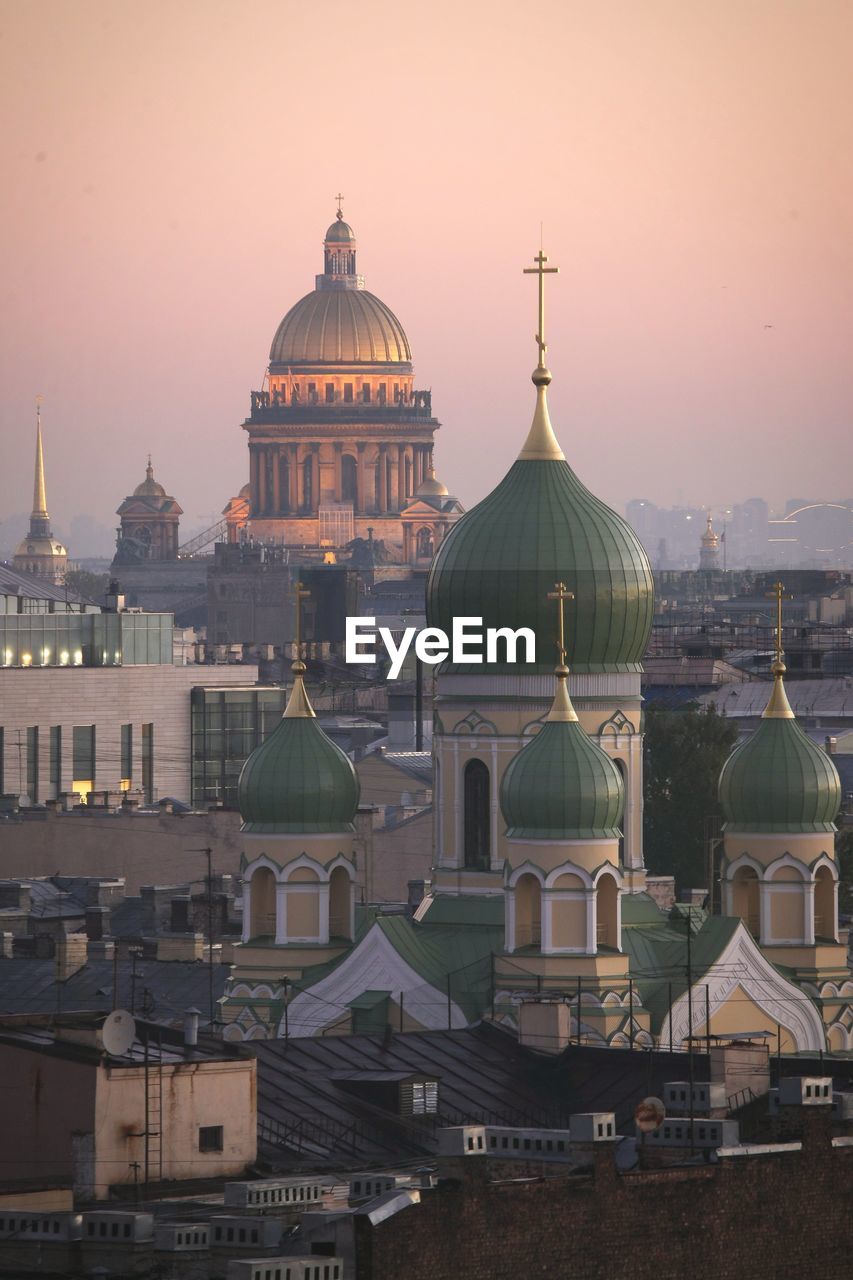 Buildings in city against sky during sunset